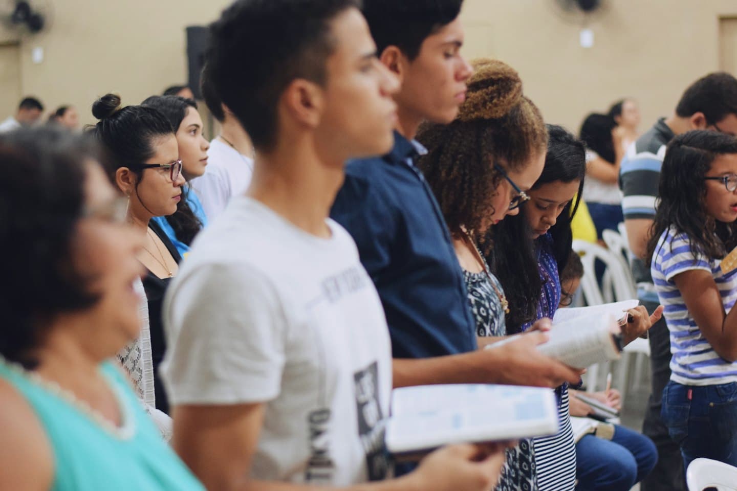 Persone di diverse età e background leggono libri insieme al chiuso.