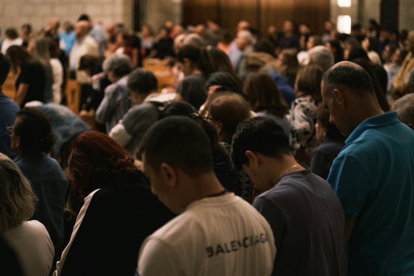 Persone diverse riunite al chiuso in un momento di riflessione.